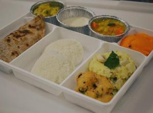 a tray of food with rice and bread and other foods at Royal Residency in Pedappai