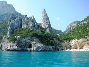 una montagna con una grotta in mezzo all'acqua di BaseCamp Ogliastra - House a Santa Maria Navarrese