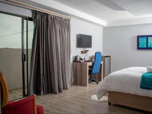 a bedroom with a bed and a desk with a computer at Bergsig Guesthouse in Bethlehem