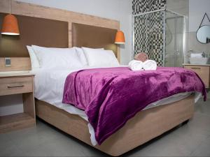a bedroom with a large bed with two towels on it at Bergsig Guesthouse in Bethlehem