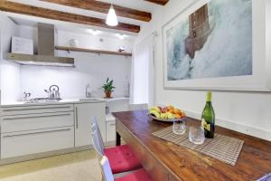a kitchen with a wooden table with a bowl of fruit at Cozy Apartment up to 4 in Biennale Giardini by Bricola Apartments in Venice