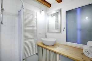a bathroom with a sink and a large screen television at Cozy Apartment up to 4 in Biennale Giardini by Bricola Apartments in Venice