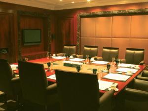 una sala de conferencias con una mesa larga y sillas en The Claridges New Delhi, en Nueva Delhi