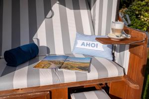 a chair with a table and a book on it at Das Frühstückshotel Büsum in Büsum