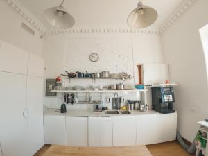 a kitchen with white cabinets and a counter top at Sunset Destination Hostel in Lisbon