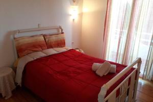 - une chambre avec un lit et une couette rouge dans l'établissement Amazing Sea View-Neos Pyrgos Beach -Evoia Greece, à Neos Pirgos