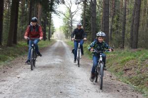 three people riding bikes down a dirt road at Grünsteinhof - Wohnung Rotstein in Habrachćicy