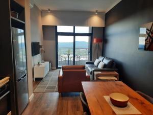 a living room with a couch and a table at MENLYN MAINE - One Bedroom Penthouse - NO LOAD SHEDDING!! in Pretoria