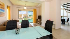 a dining room with a blue table and chairs at Blue Mare Villa Rethimno in Magnisía