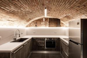 a kitchen with a sink and a brick wall at RB del Teatro&Apartaments in Imola