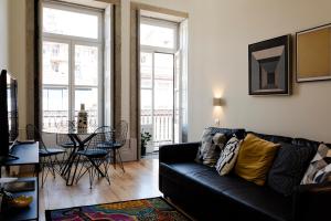 a living room with a black couch and a table at NorteSoul Mouzinho in Porto