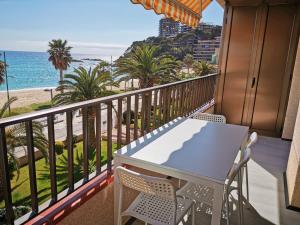 a balcony with a table and chairs and the beach at Apartaments Primera Linea Torre Valentina in Sant Antoni de Calonge