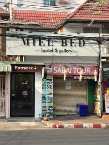 a store with a sign on the side of a street at MIEL BED Hostel & Gallery in Chiang Mai