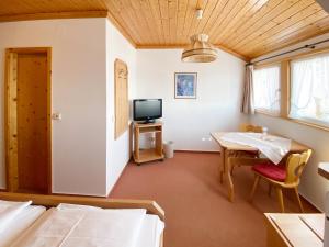 Zimmer mit 2 Betten, einem Tisch und einem TV in der Unterkunft Landgasthof Rößle in Berau