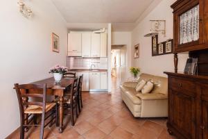 una cucina e un soggiorno con tavolo e divano di Residence Isola Verde Cisanello a Pisa