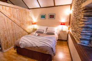 una camera con un letto con due lampade e una parete di mattoni di Gites des Esperelles a Saint-Privat-de-Vallongue