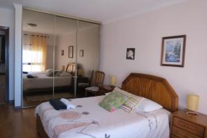 un dormitorio con una cama y un espejo en Olá Ericeira Apartment, en Ericeira 20 fotos más