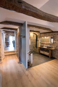 un ampio bagno con parete in pietra e soffitti in legno di Gites des Esperelles a Saint-Privat-de-Vallongue Altre 6 foto