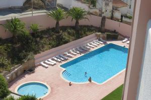 una vista aérea de una piscina con tumbonas en Olá Ericeira Apartment, en Ericeira