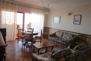una sala de estar con un sofá y una mesa en Olá Ericeira Apartment, en Ericeira