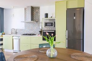 a kitchen with a table with a vase with flowers on it at Stay In Carabassi II in Gran Alacant +11 photos