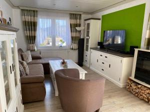 uma sala de estar com um sofá e uma televisão em Macke`s Ferienwohnungen em Hahnenklee-Bockswiese