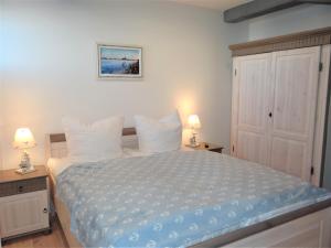 una camera da letto con un grande letto con cuscini bianchi di Speicher Residenz Barth E1 App 3 a Barth