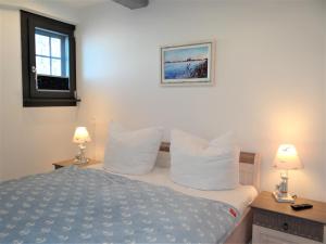 una camera da letto con un letto con cuscini bianchi e 2 lampade di Speicher Residenz Barth E1 App 3 a Barth