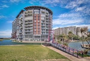a large apartment building next to a body of water at Durban Point Waterfront, 304 The Quays in Durban