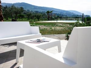 a white bench sitting on a patio with a view at Resilienza Apartment in Capo dʼOrlando