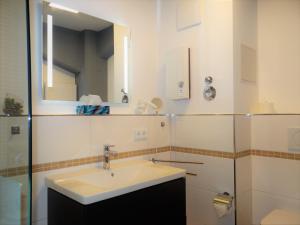 bagno bianco con lavandino e specchio di Speicher Residenz Barth E1 App 3 a Barth