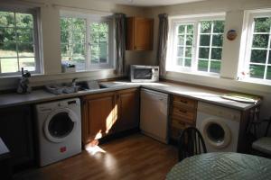 a kitchen with washing machines and a sink and windows at Mingulay, Cuil Bay in Appin
