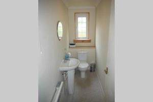 a white bathroom with a sink and a toilet at Mingulay, Cuil Bay in Appin