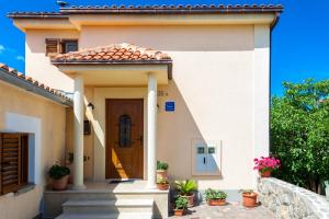 une maison blanche avec une porte et des fleurs dans l'établissement Apartments Dario, à Porat