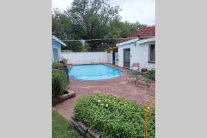 a backyard with a swimming pool and a house at Trinity Cottage in Vanderbijlpark