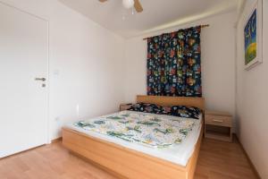 a bedroom with a bed with a curtain on the wall at Sofia's Apartments in Biograd na Moru