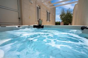 a hot tub with blue water inside of a building at Apartments Villa Azzurra Bol in Bol