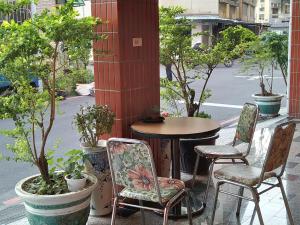 a table and chairs on a patio with trees at The LEY HOTEL 寶麗頌旅館 in Tainan