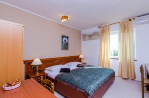 a bedroom with a bed and a table and a window at Apartments Nicol in Dubrovnik