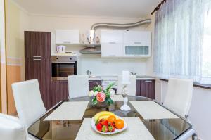 a kitchen with a glass table with fruit on it at Apartments Nicol in Dubrovnik