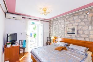 a bedroom with a large bed and a tv at Apartments Nicol in Dubrovnik