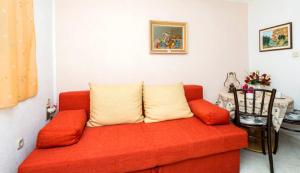 a red couch with two pillows in a living room at Apartments Nicol in Dubrovnik