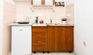 a small kitchen with a sink and a refrigerator at Apartments Nicol in Dubrovnik