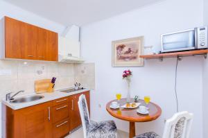 a small kitchen with a table and a sink at Apartments Nicol in Dubrovnik
