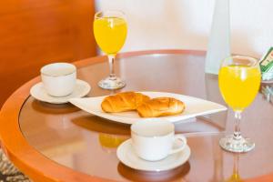 a table with two glasses of orange juice and croissants at Apartments Nicol in Dubrovnik