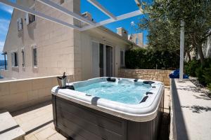 a hot tub in the backyard of a house at Apartments Villa Azzurra Bol in Bol