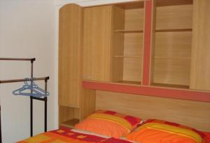 a bedroom with a wooden book shelf and a bed at Apartment in Lopar with Terrace, Air condition, WIFI, Dishwasher (4224-4) in Lopar