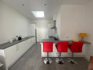 a kitchen with two red chairs and a counter at Apt 4 - Silver Spruce in Killarney