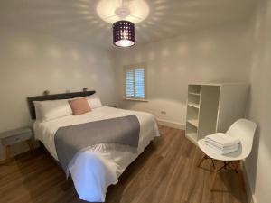 a bedroom with a bed and a table and a chair at Apt 4 - Silver Spruce in Killarney