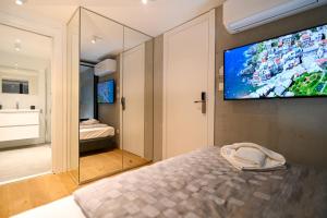 a bedroom with a bed with a television on the wall at The Place Apartments Split in Split